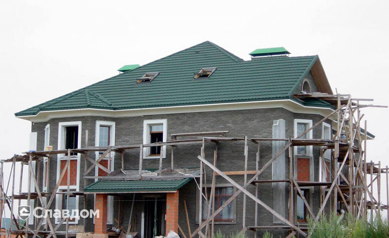 Двухэтажный загородный дом с покрытием крыши из композитной черепицы METROTILE МетроБонд зеленый